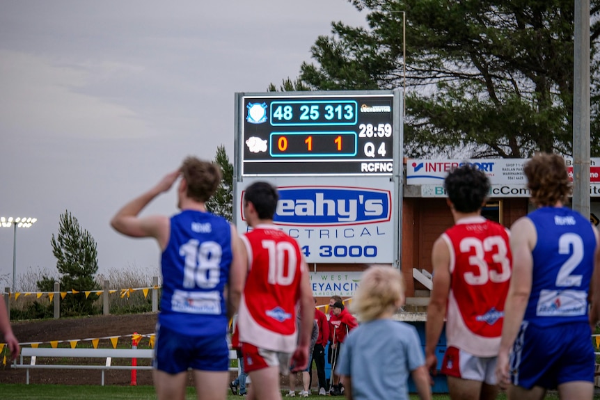 A scoreboard readds 313 to 1 as players walk off the field under grey skies