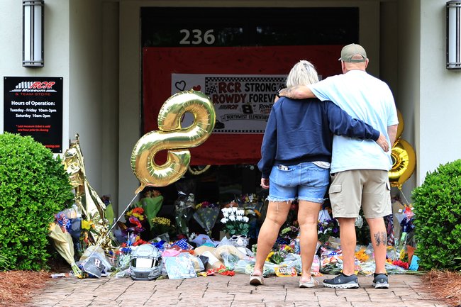 Fans gather at the memorial outside of the entrance to the Richard Childress Racing Museum where items have been placed in memory of Kyle Busch.
