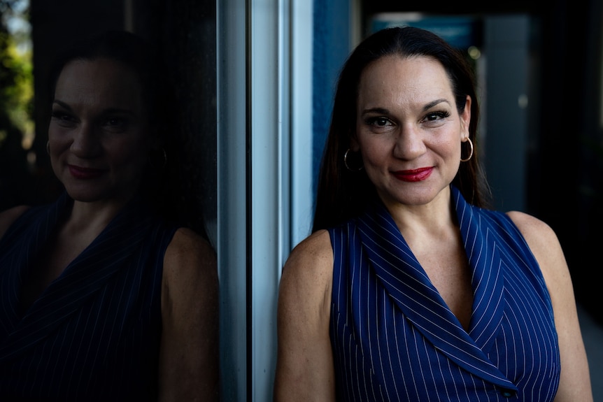 A woman in a blue shirt posing for a photo.