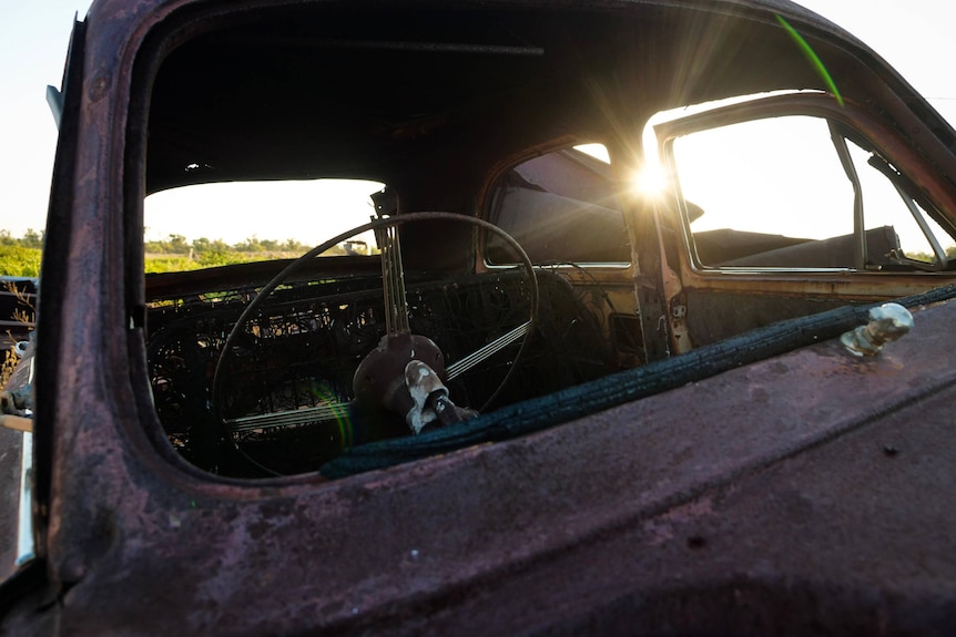 Sunlight shines through the cab of a seventies-era car.