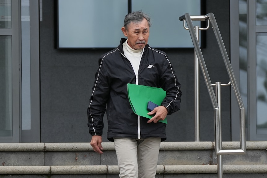 A medium of a man holding a green folder 