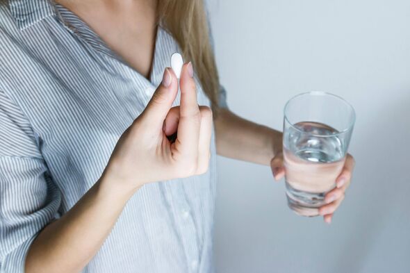 a woman taking a pill a woman taking a pill