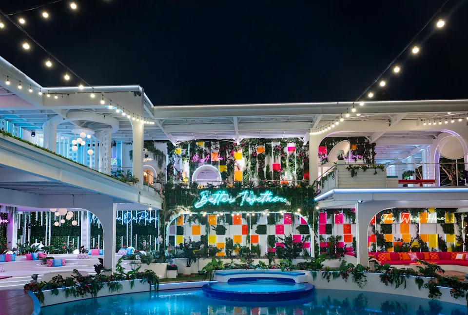 a vibrant and modern recreational space at night with neon signage and lush plants