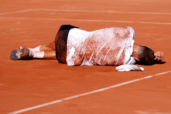 Jakub Mensik collapses after his four-set victory in almost five hours of heat.