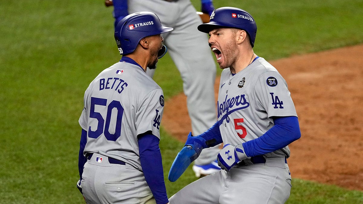 Los Angeles Dodgers' Mookie Betts and Freddie Freeman celebrating during baseball game.