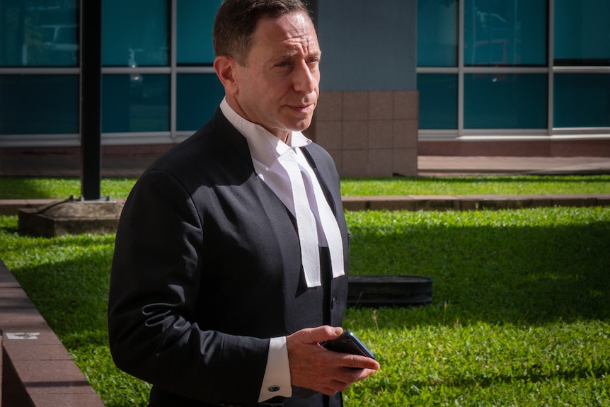 Barrister in robes walking into court on a sunny day