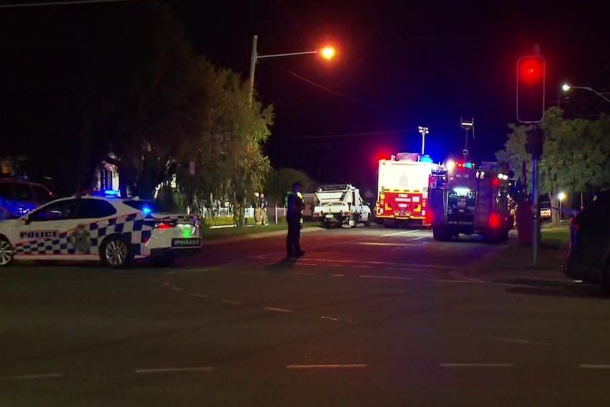 Police cars and a fire truck on  street at night. 