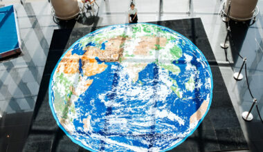 thousands of paper quills compose monumental mosaic earth artwork