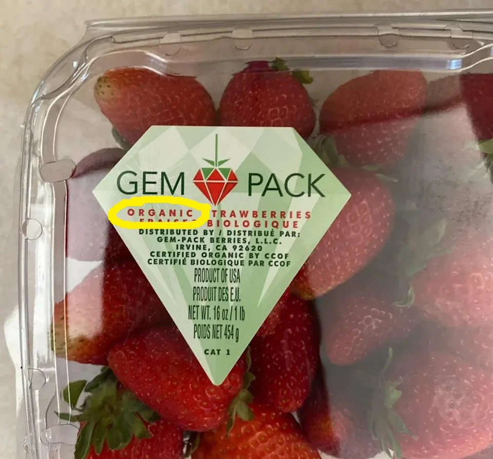 Pack of organic strawberries labeled "Gem Pack," displayed in a plastic container