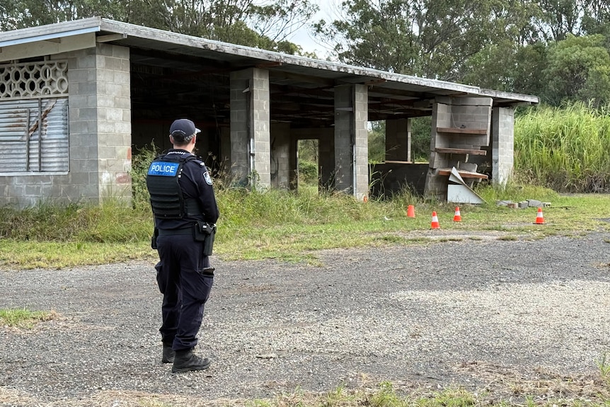 Police at the exterior of an abandoned property.