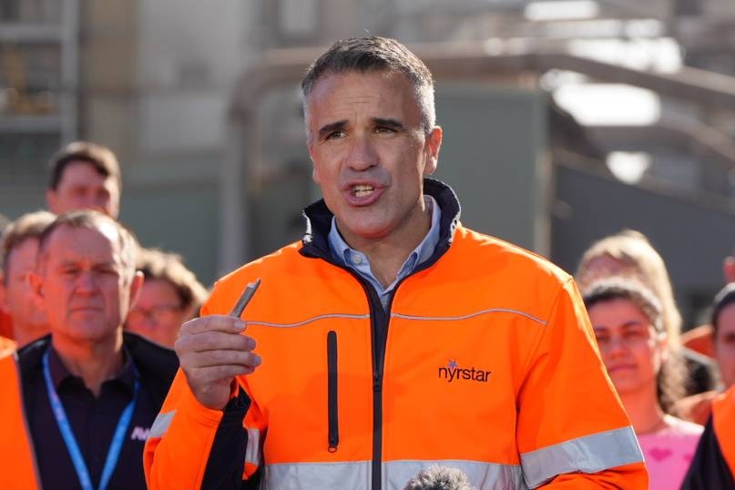 Peter Malinauskas holding a piece of metal.