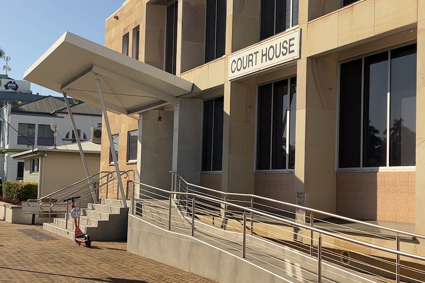A sandstone building with a ramp and stairs, with a sign reading 'courthouse'