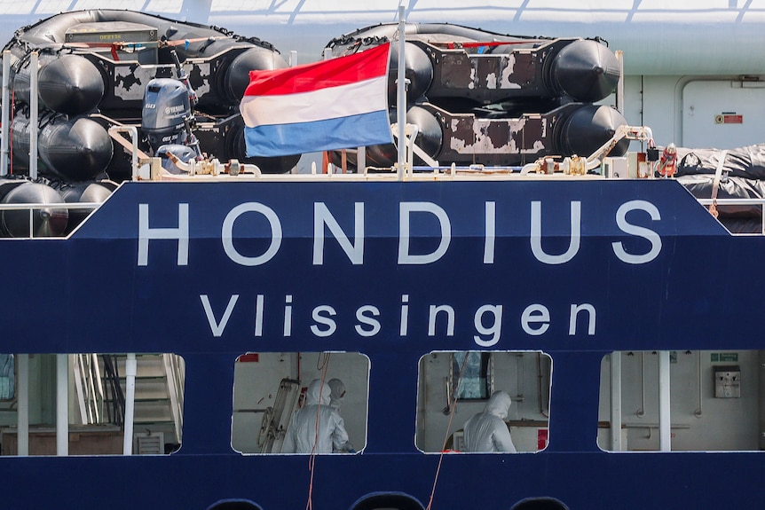 people wearing PPE can be seen insed a cruise ship