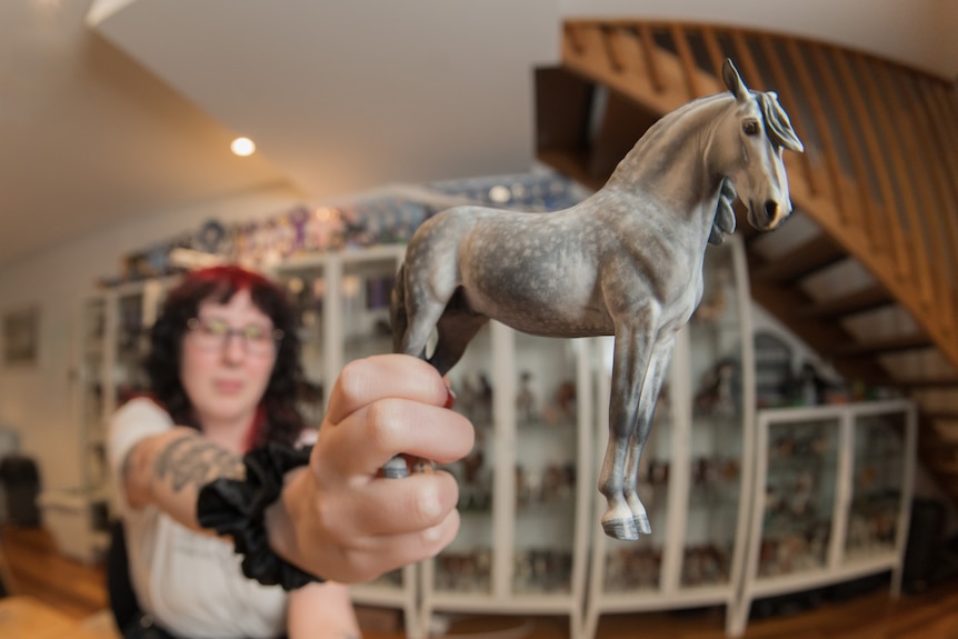 May out of focus holds grey model horse