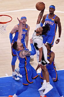 Stephon Castle of the San Antonio Spurs drives to the rim over Isaiah Hartenstein of the Oklahoma City Thunder.