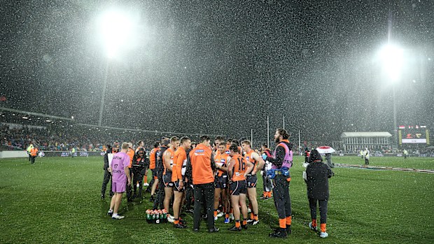 Leon Cameron, coach of the Giants, speaks to players at quarter time as snow falls during the round 21 AFL match between the Greater Western Sydney Giants and the Hawthorn Hawks at UNSW Canberra Oval on August 09, 2019 in Canberra, Australia. (Photo by Mark Metcalfe/AFL Photos/via Getty Images)