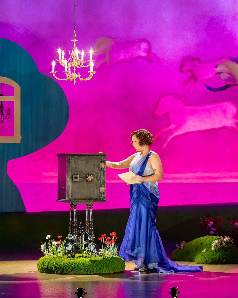 A performer interacts with a decorative mailbox on stage.