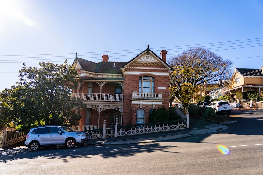 Old federation-era homes on a sunny street sloping upwards.
