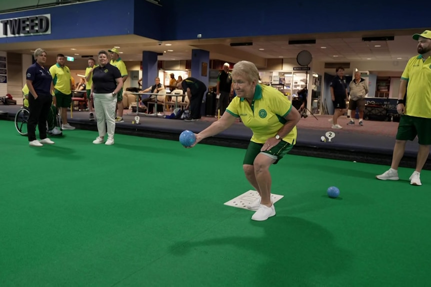 Australian lawn bowls athlete Jacky Hudson prepares to bowl on a green.
