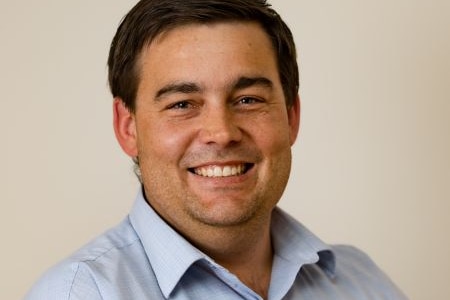 A man smiles into the camera