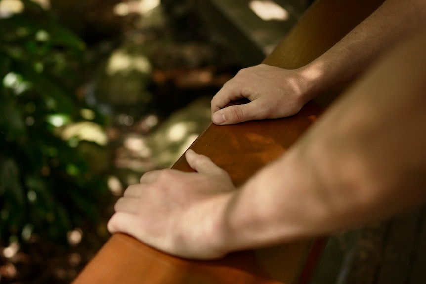 A pair of hands on a railing