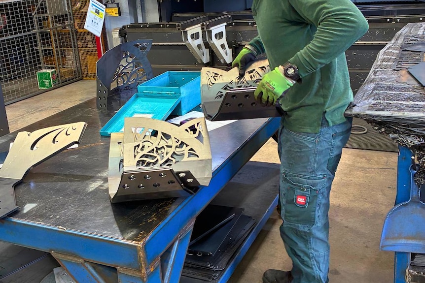 man carrying decorative bits of steel