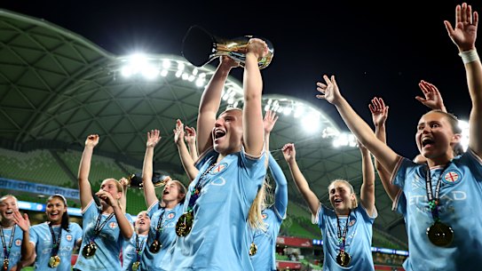 Holly McNamara and her teammates celebrate with the trophy.