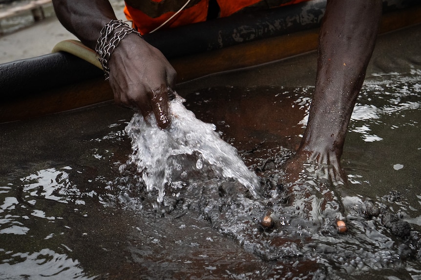 Lincy the alluvial mine worker washing his hands at Panguna mine.