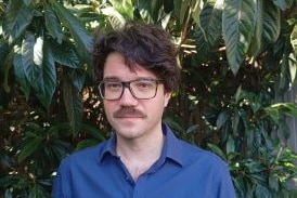 portrait of man in bushes or trees.