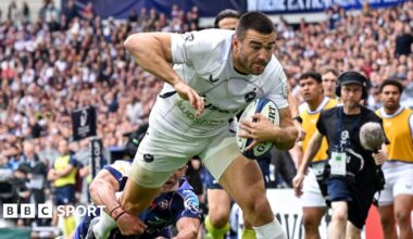Will Muir dives towards the line with the ball under his left arm as a Bordeaux player wraps his arm around his right leg in an attempt to prevent a try during their Champions Cup match