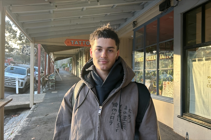 A young man looks at a camera
