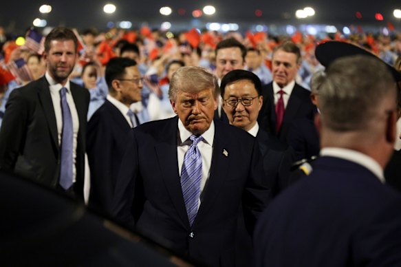 President Donald Trump walks to his motorcade as he is greeted by Chinese officials at Beijing Capital International Airport. 