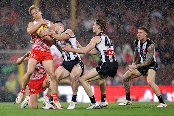 Daniel McStay of the Magpies tackles Isaac Heeney of the Swans.