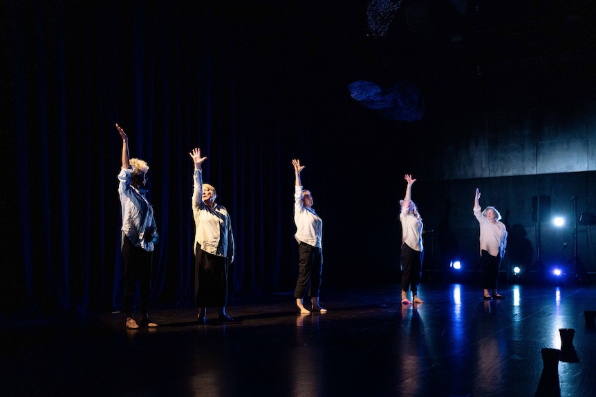 Mature-aged women doing dance practise in a studio with blue light