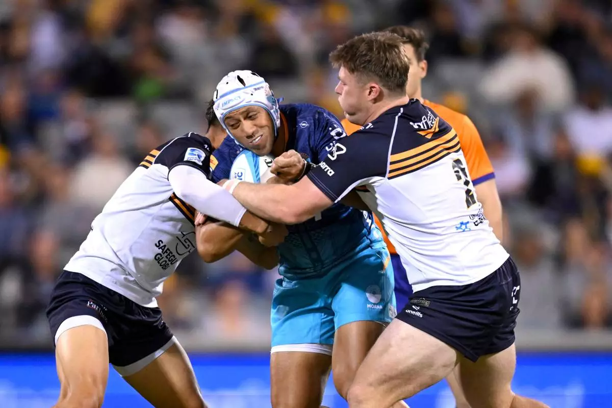 FILE - Christian Lealiifano of Moana Pasifika is tackled by Billy Pollard of the Brumbies during the Super Rugby Pacific Round 5 match between the ACT Brumbies and Moana Pasifika in Canberra, Friday, March 22, 2024. (Lukas Coch/AAP Image via AP, File)