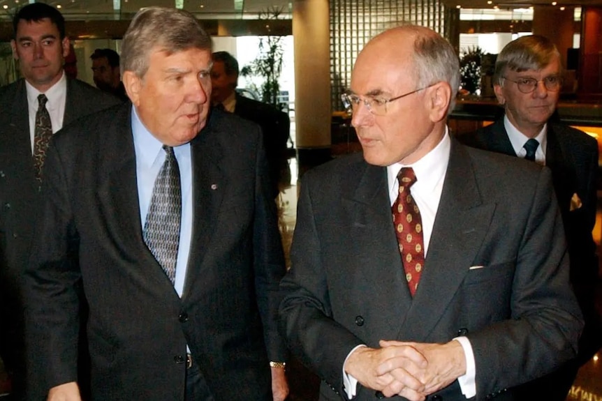 Two men wearing suits standing next to each other.