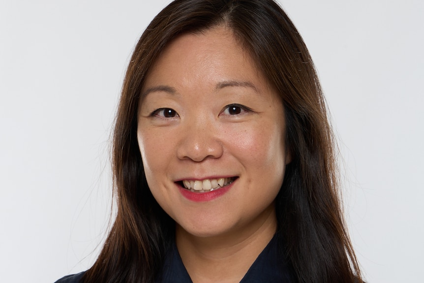 Woman with long dark hair smiles at the camera.