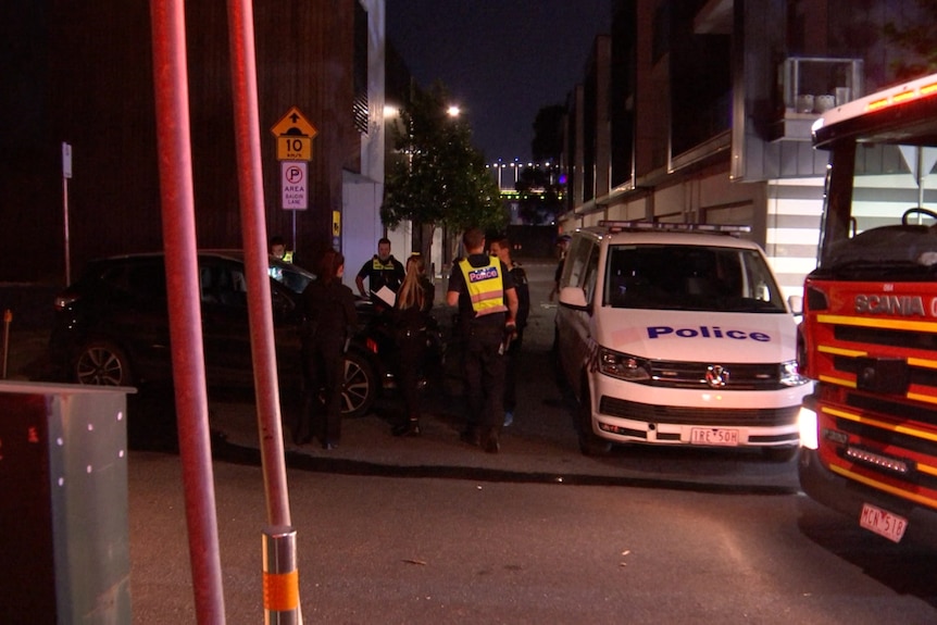 Police stand on the street at night, near the scene of the Almina arson attack.