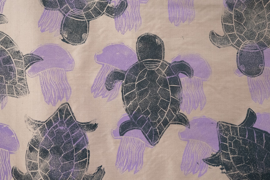 Block printed fabric with black turtle and purple jellyfish design