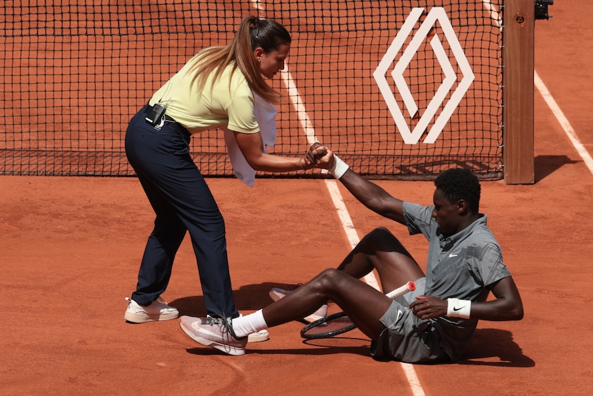 Ana Carvalho helps Moise Kouame up off the court