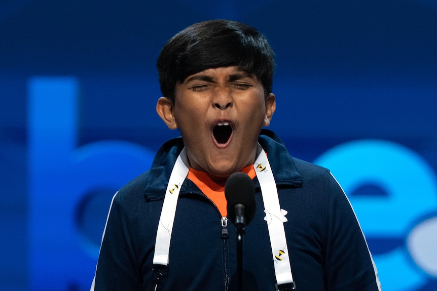A boy with his eyes squeezed shut and mouth open