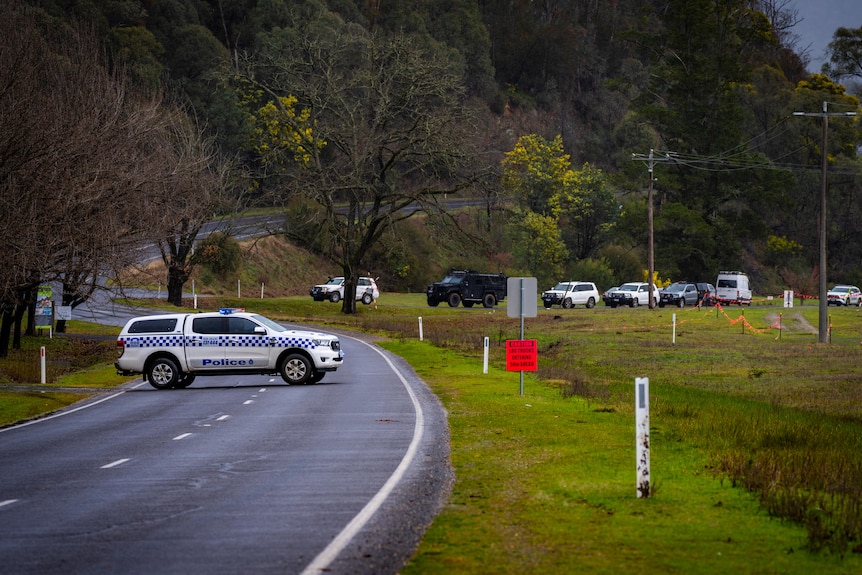 Police cars on a country road.
