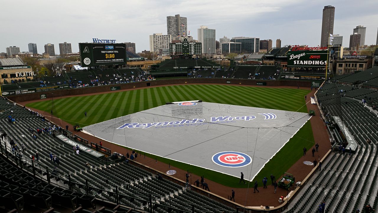 A rain tarp covers the infield at Wrigley Field during a rain delay before a baseball game. (AP Photo/Paul Beaty)