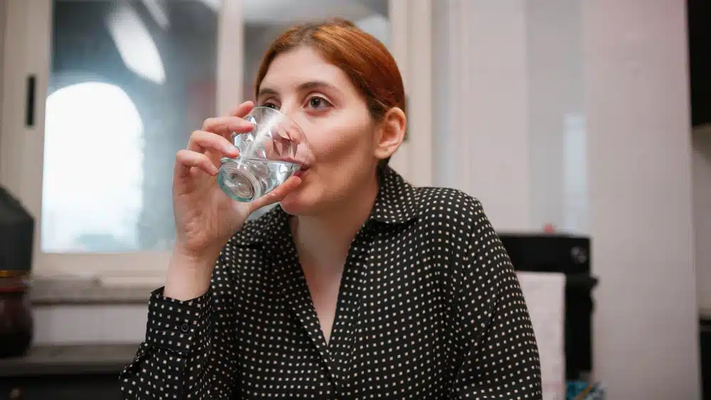 Sitting,at,the,table,a,woman,drinks,fresh,water,on