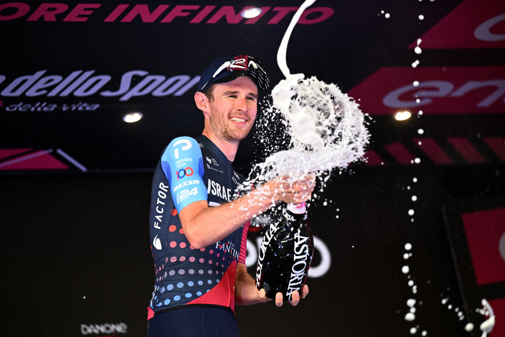 Gee spraying prosecco from the podium
