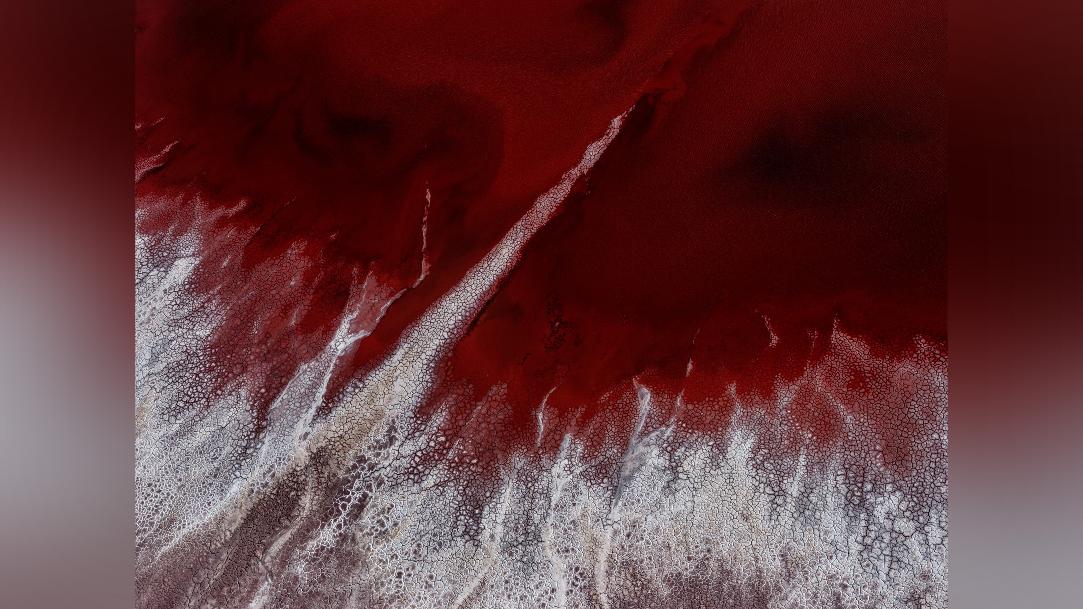 Colorful patterns in landscape produced by industrial mineral extraction.