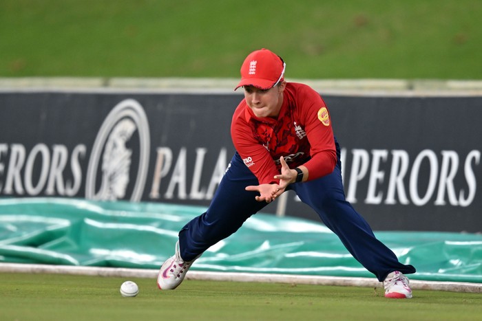 Alice Capsey England cricketer Alice Capsey, in red and blue kit, fields a ball on the boundary.