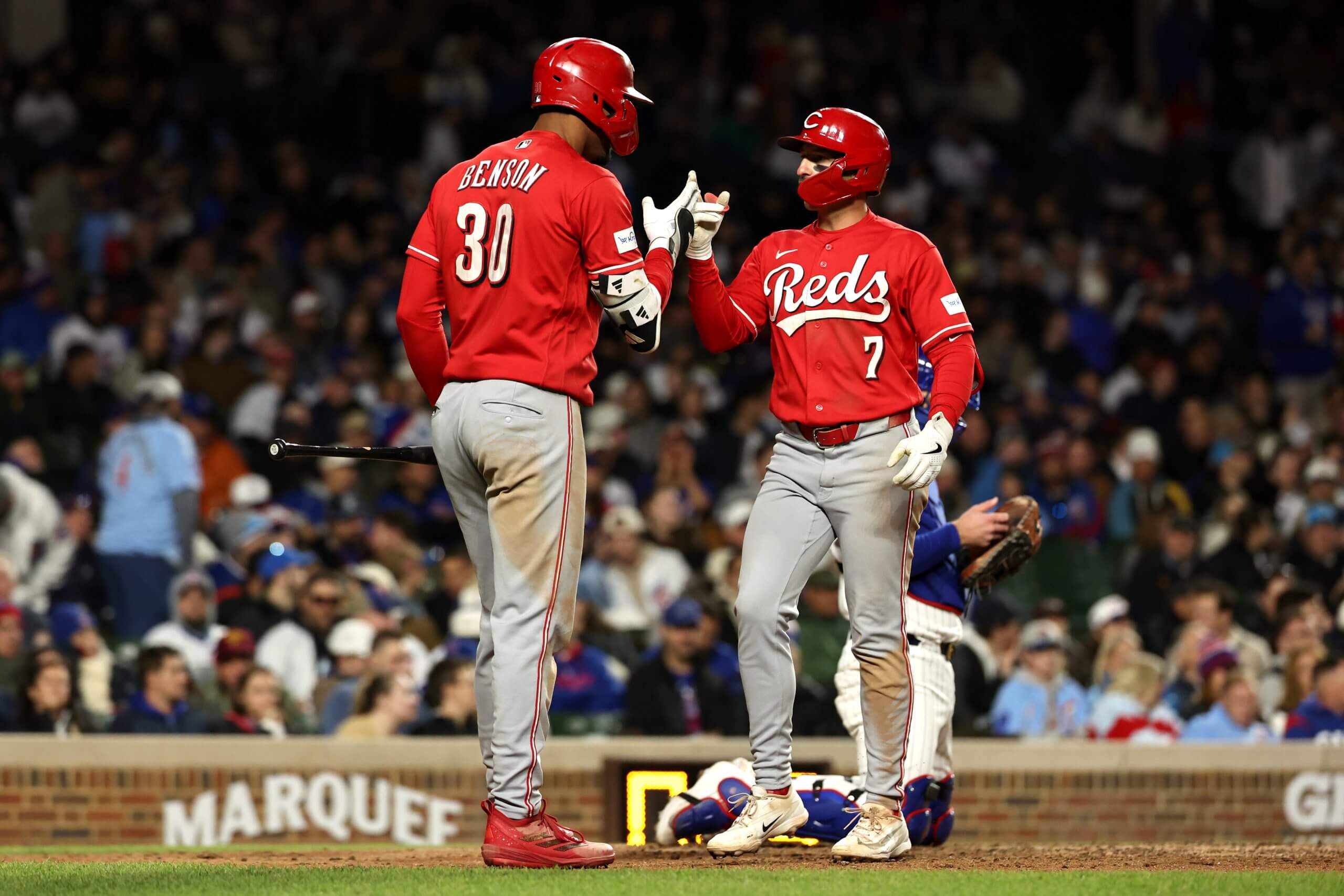 Spencer Steer (No. 7) of the Cincinnati Reds celebrates with teammate Will Benson (No. 30) after his ninth-inning home run.