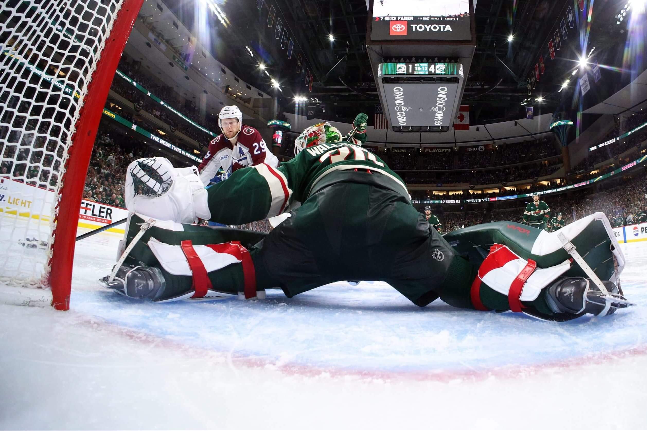 Minnesotas goalie Jesper Wallstedt stretches out as Colorado's Nathan MacKinnon bears down.