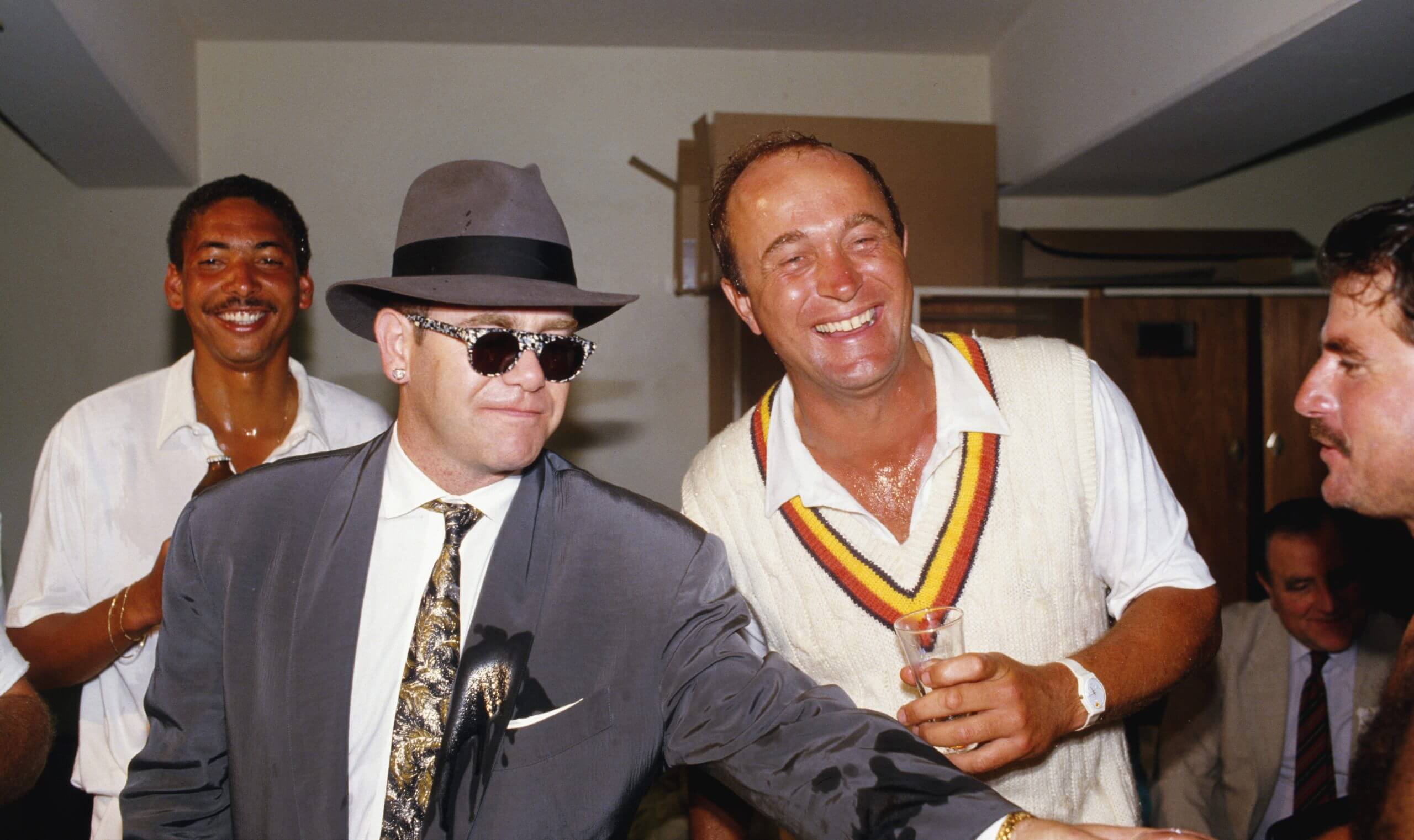 England's Phil de Freitas (left), Phil Edmonds and Allan Lamb share a celebratory glass of Champagne with Elton John in the dressing room after their Ashes victory Down Under in 1986